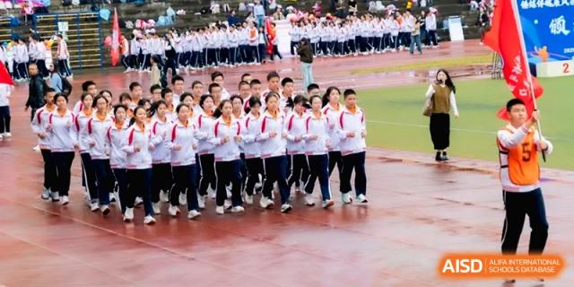 A large formation of students in white uniforms march on the track at the Affiliated High School of Fujian Normal University.