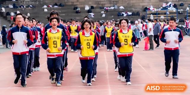 Students in blue uniforms and yellow bibs run together during a race at the Affiliated High School of Fujian Normal University.
