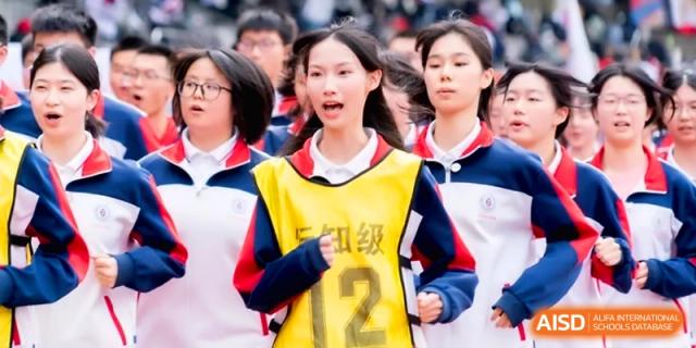 A female student wearing a yellow bib numbered twelve runs on a track at the Affiliated High School of Fujian Normal University.