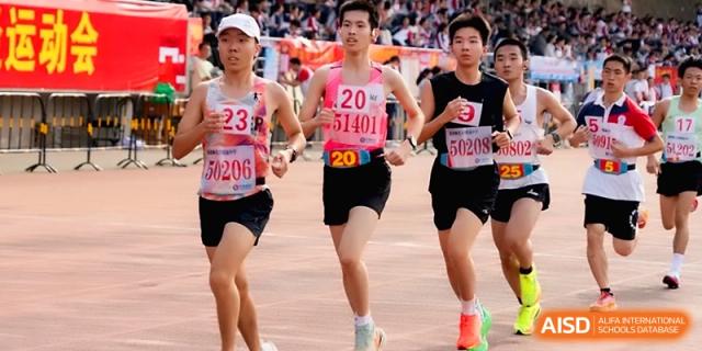 Male runners with bib numbers compete in a distance race on the track at the Affiliated High School of Fujian Normal University.