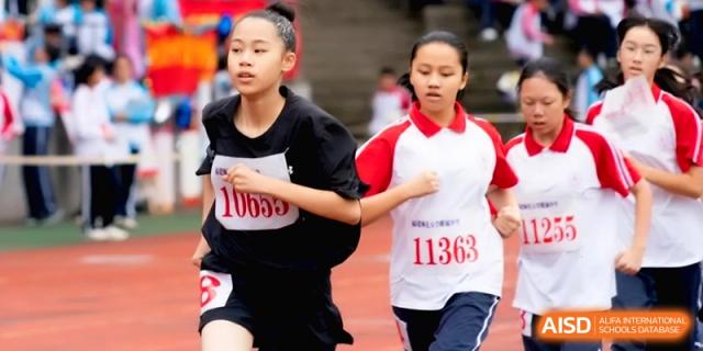 Two female students in black and red athletic gear compete in a race at the Affiliated High School of Fujian Normal University.