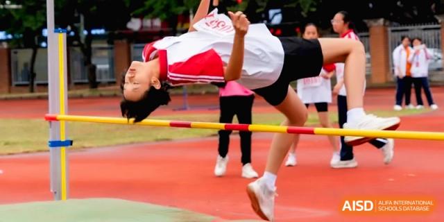 A female student athlete clears the high jump bar in a stadium at the Affiliated High School of Fujian Normal University.
