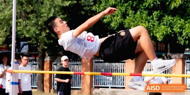 A male student athlete performs a high jump over a yellow bar at the Affiliated High School of Fujian Normal University.