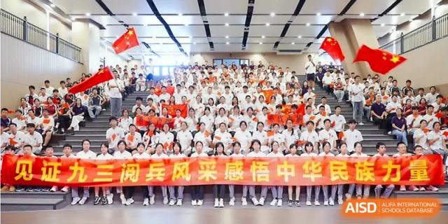 A large group of students posing together for a commemorative photo in an auditorium at the Affiliated High School Of Peking University Haikou.