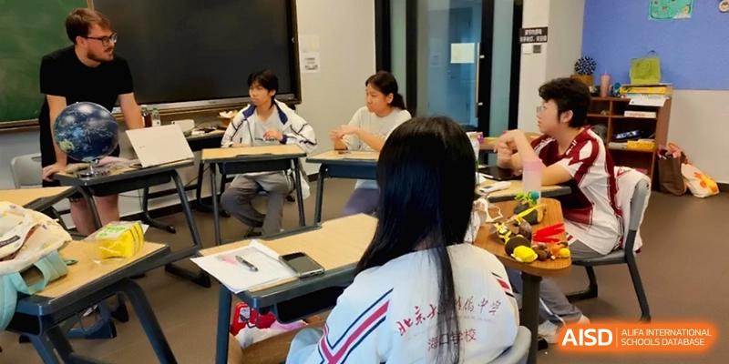 Students engaged in a collaborative classroom discussion while sitting at their desks at the Affiliated High School Of Peking University Haikou.
