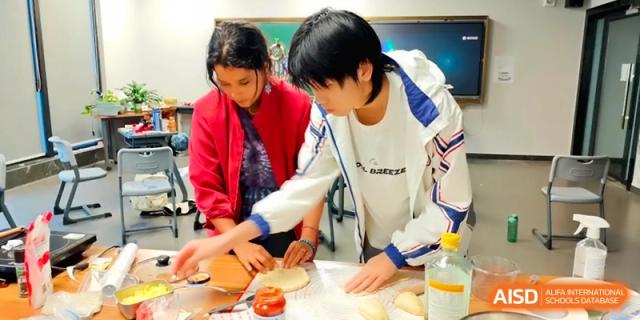 Two students collaborate on a hands-on project during a practical science or art lesson at the Affiliated High School Of Peking University Haikou.