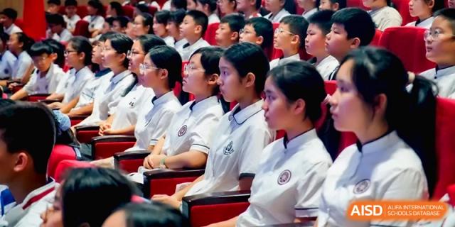 Close-up of students in white uniforms listening attentively during an assembly at the Affiliated High School Of Peking University Haikou.