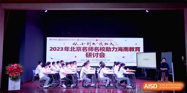 Students sit at long tables on a stage during an educational forum or symposium at the Affiliated High School Of Peking University Haikou.