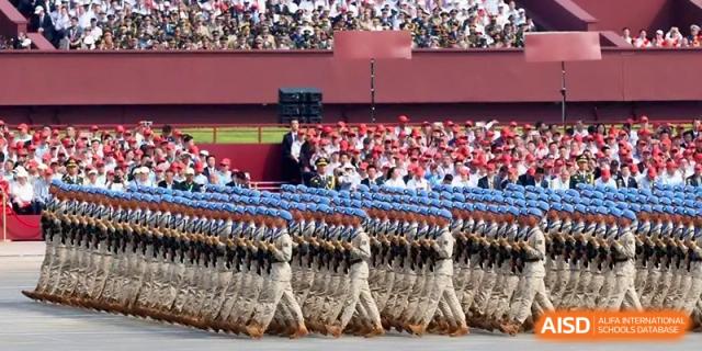 Students in military-style uniforms march in formation during a school parade at the Affiliated High School Of Peking University Haikou.