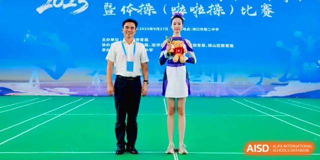 A student and teacher posing with an award during a sports ceremony at the Affiliated High School Of Peking University Haikou.