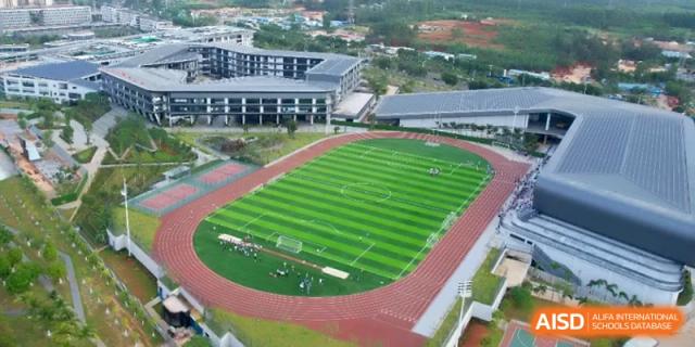 An aerial view of the large outdoor running track and soccer field at the Affiliated High School Of Peking University Haikou.