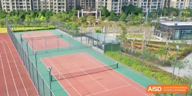 A high-angle view of the outdoor tennis and volleyball courts at the Affiliated High School Of Peking University Haikou.