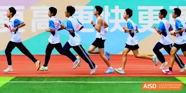 Male athletes compete in a sprint race on a green and red track during a competitive school sports competition at Baoji Nanshan High School.