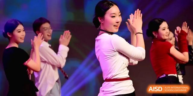 A female performer in traditional white and red clothing dances gracefully during a cultural talent showcase at Baoji Nanshan High School.