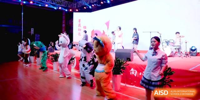Students dressed in various colorful animal mascot costumes dance and entertain the audience during a festive event at Baoji Nanshan High School.