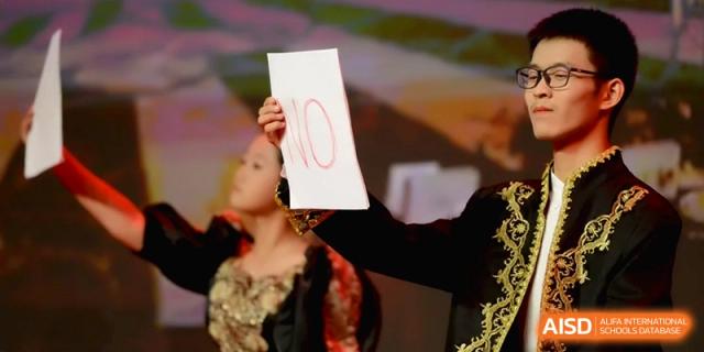 A student in a period costume holds up a handwritten "NO" sign during a dramatic stage performance for her peers at Baoji Nanshan High School.