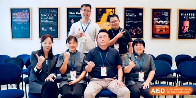 A group of faculty members poses for a formal team photo indoors at Beijing Eastbank Academy of Music.