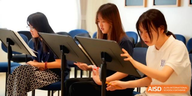 A student focuses on her sheet music while sitting in a practice room at Beijing Eastbank Academy of Music.