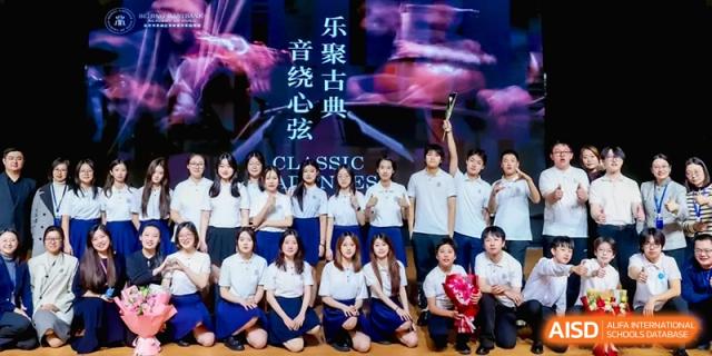 A large group of students in uniforms poses for a commemorative photo on a stage at Beijing Eastbank Academy of Music.