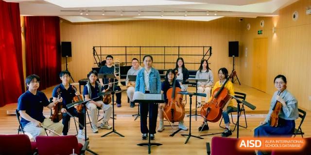 A student ensemble featuring strings and woodwinds prepares for a performance at Beijing Eastbank Academy of Music.