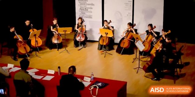 Four students playing cellos on stage during a formal ensemble performance at Beijing Eastbank Academy of Music.