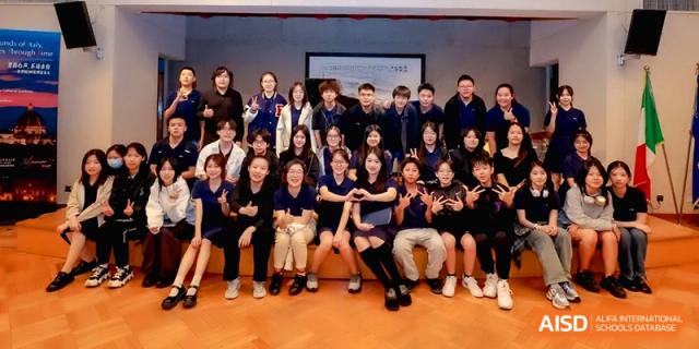 A large group of students and staff posing for a commemorative photo in a studio at Beijing Eastbank Academy of Music.