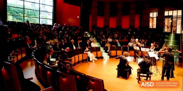 An interior view of a dark concert hall filled with an audience during a show at Beijing Eastbank Academy of Music.