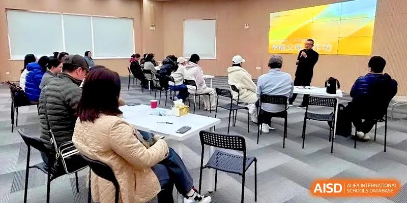 A group of parents and faculty attending a presentation in a modern multipurpose room at HD Beijing School.