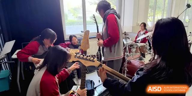 Students practice their musical instruments, including guitars and drums, in a music room at Qingdao Experimental High School.