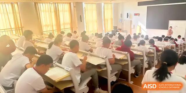 Rows of students are seen from behind while studying in a sun-drenched classroom at Qingdao Experimental High School.