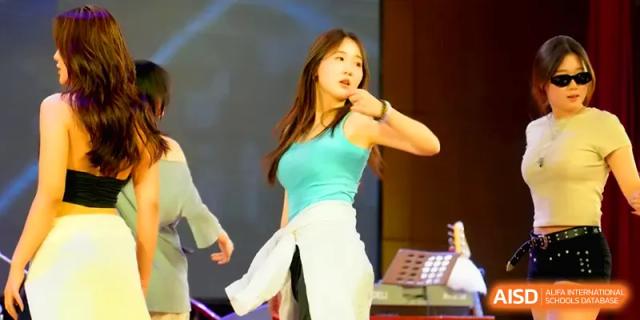 A female student performs a modern dance routine on stage during a talent show at Qingdao Experimental High School.