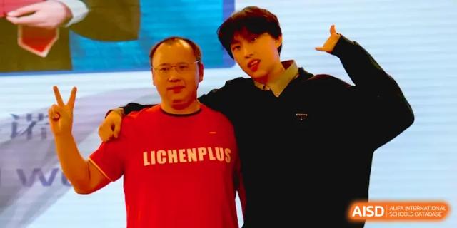 A teacher and student pose for a friendly photo during a school event at Qingdao Experimental High School.