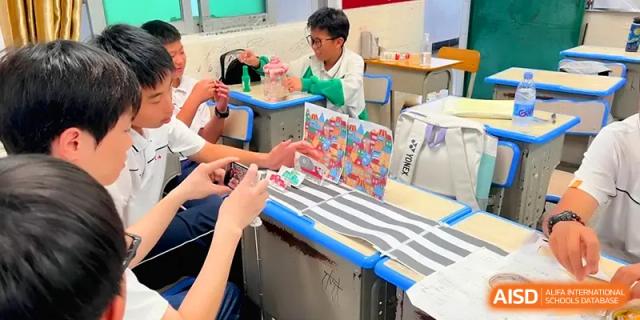 Students collaborate on a creative project involving colorful paper and crafts at their classroom desks during a hands-on learning session at Quanzhou No. 5 Middle School.