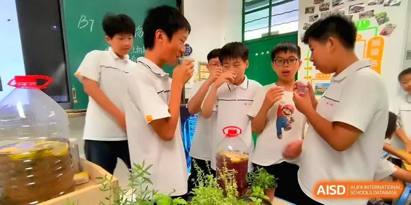 A group of boys in white uniforms participate in a science experiment or tasting activity in a classroom at Quanzhou No. 5 Middle School.