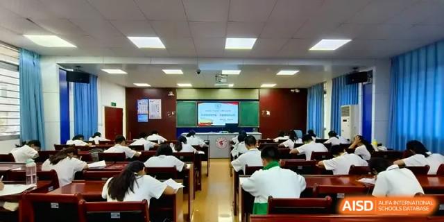 An overview of a large lecture hall filled with students during a formal presentation or academic assembly at Quanzhou No. 5 Middle School.