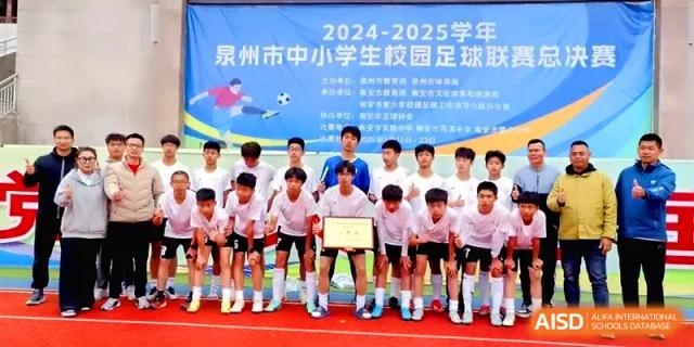 A student soccer team poses with a trophy and banner on a red running track after a sports match at Quanzhou No. 5 Middle School.