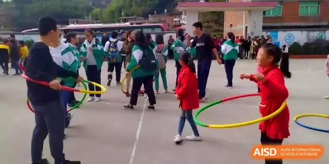 Students enjoy outdoor playtime with hula hoops and sports equipment on the school playground at Quanzhou No. 5 Middle School.