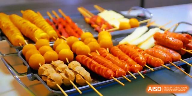 Assorted skewers of grilled meats and fish balls prepared for a student festival or cafeteria meal at Quanzhou No. 5 Middle School.