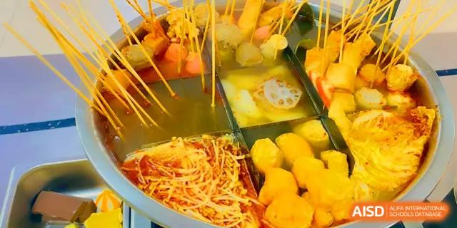 A selection of oden and hot pot ingredients simmering in a divided metal pot in the cafeteria at Quanzhou No. 5 Middle School.