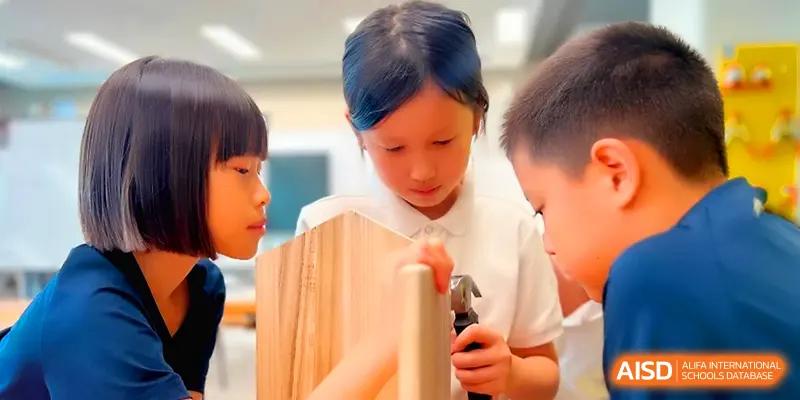 Students engage in a hands-on woodworking project using tools to shape a wooden piece at Shenzhen Mingwan School.