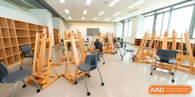 An art studio equipped with several wooden easels and stools for creative projects at Shenzhen Mingwan School.