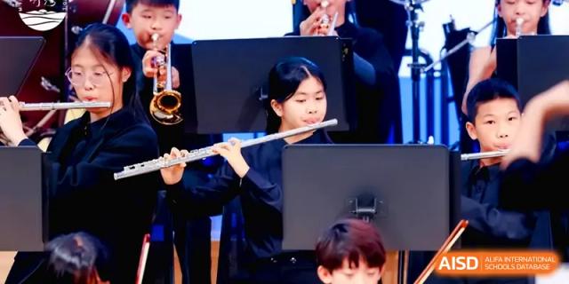 A student flutist performing as part of a school woodwind ensemble during a concert at Shenzhen Mingwan School.