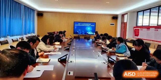 Staff members gather around a long wooden table for a formal meeting in a conference room at The Guandu Experimental School Affiliated To Shanghai Normal University.