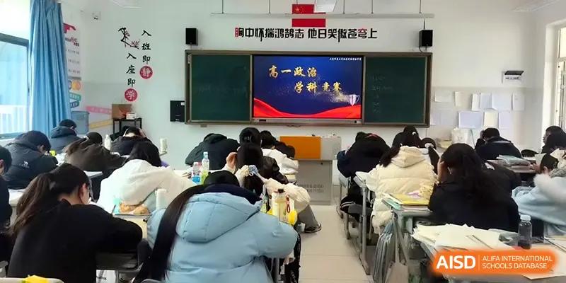 An educational presentation is shown on a screen to a classroom full of seated students at The Guandu Experimental School Affiliated To Shanghai Normal University.
