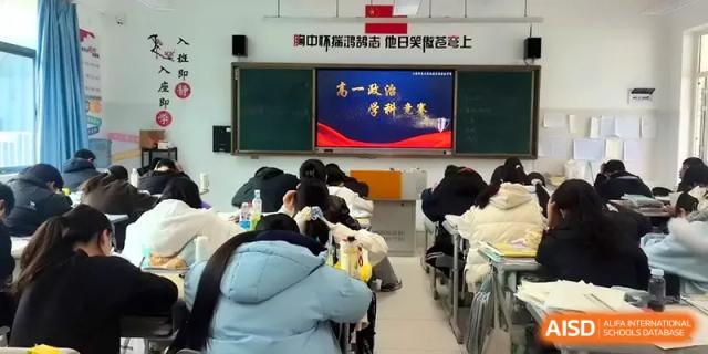 An educational presentation is shown on a screen to a classroom full of seated students at The Guandu Experimental School Affiliated To Shanghai Normal University.