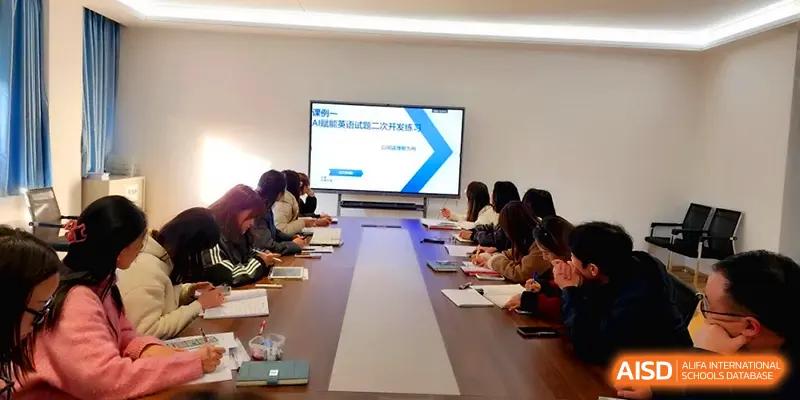 Educators gather for a meeting featuring a digital presentation on a large monitor at The Guandu Experimental School Affiliated To Shanghai Normal University.