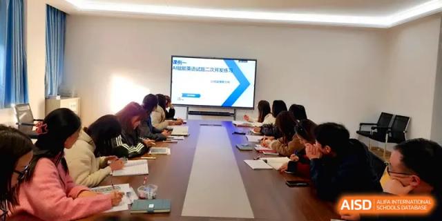 Educators gather for a meeting featuring a digital presentation on a large monitor at The Guandu Experimental School Affiliated To Shanghai Normal University.