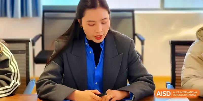 A female staff member in a blazer participates in a professional discussion at The Guandu Experimental School Affiliated To Shanghai Normal University.