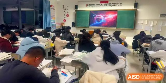 A classroom of students in winter jackets takes notes during an interactive digital lesson at The Guandu Experimental School Affiliated To Shanghai Normal University.