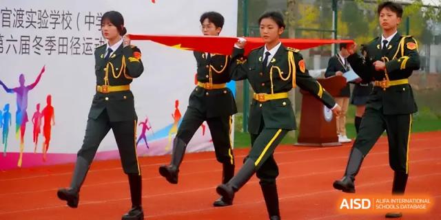 Students in green and gold dress uniforms march during a formal ceremony at The Guandu Experimental School Affiliated To Shanghai Normal University.